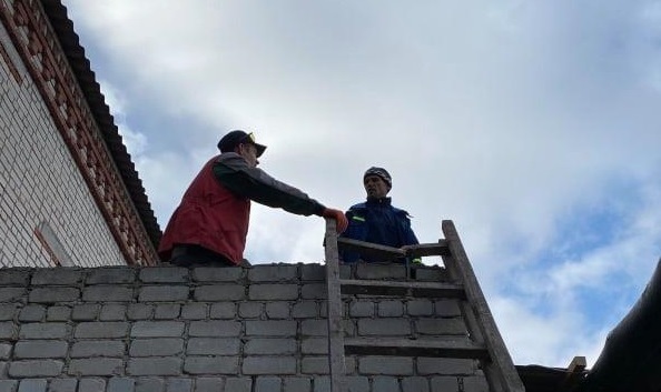 Робітники фермерських господарств ремонтують покрівлю казарми