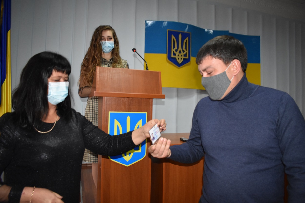 Член Нижньосірогозької ТВК Олена Пономаренко вручає посвідчення Валерію Тимошенку