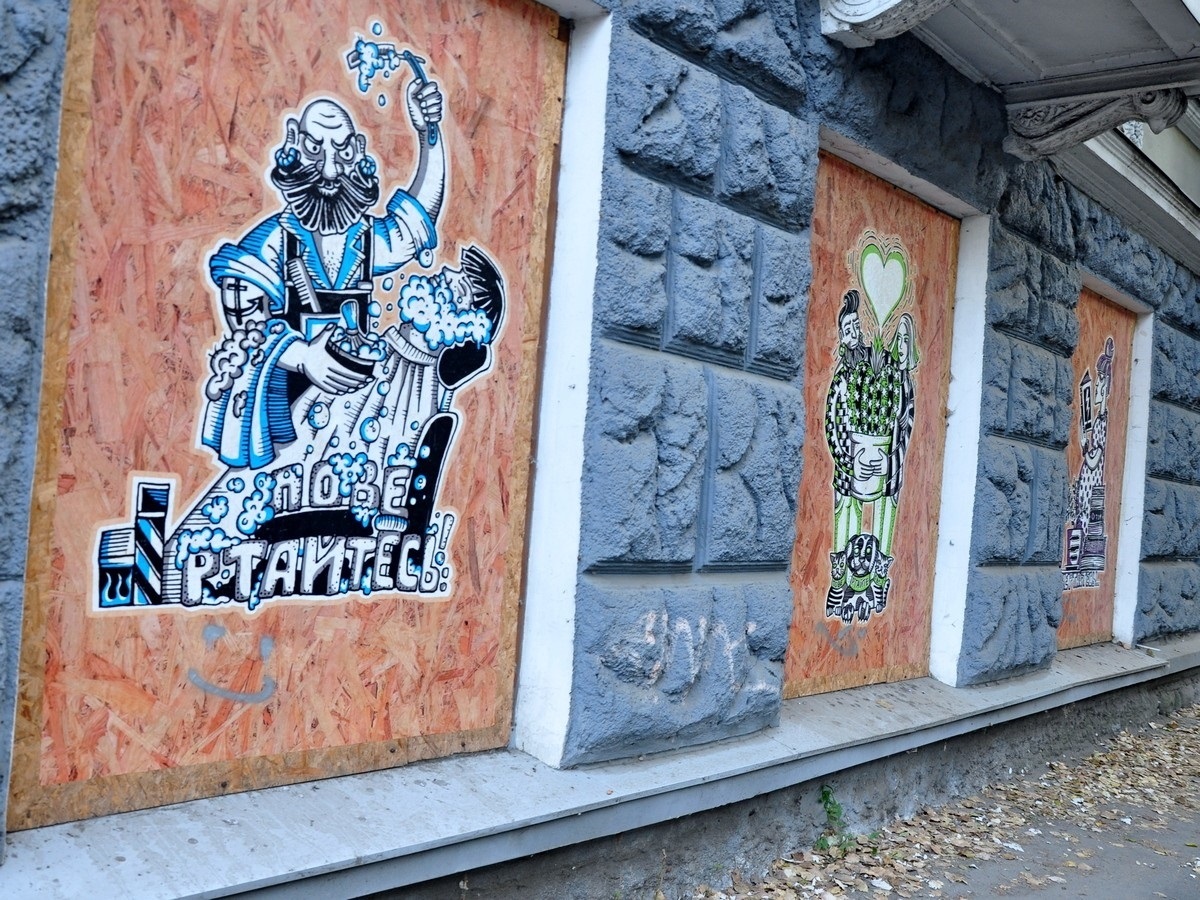 Вибиті вікна закриті плитами ДСП з роботами херсонських митців