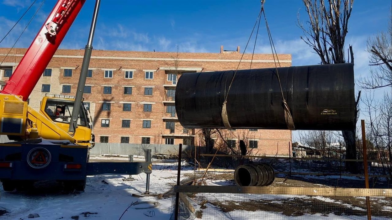 Будівництво комунікацій біля одного з відновлених будинків в Авдіївці